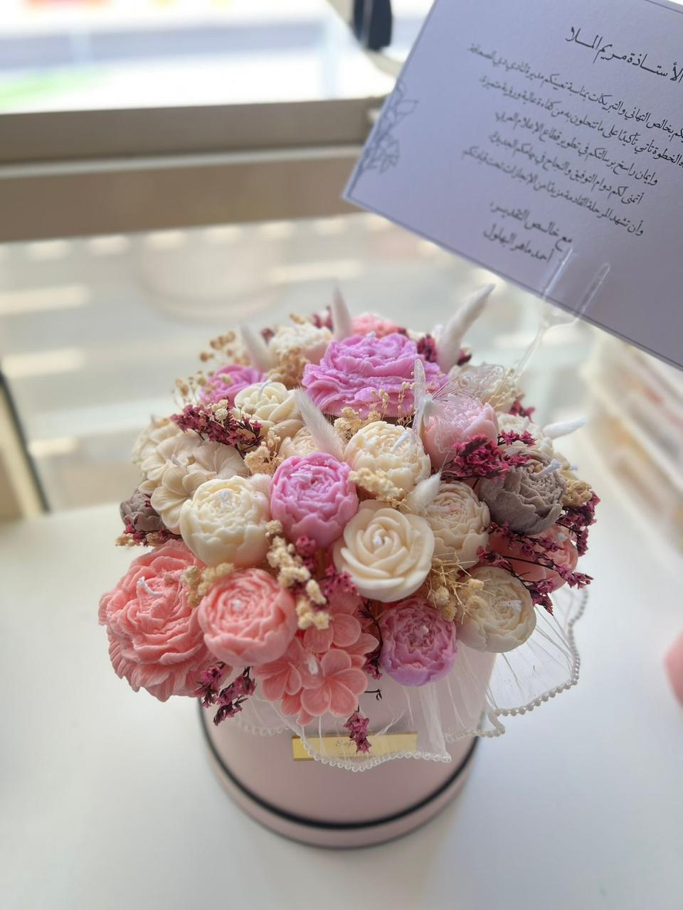 Pink ivory and lilac wax flowers in a round hatbox