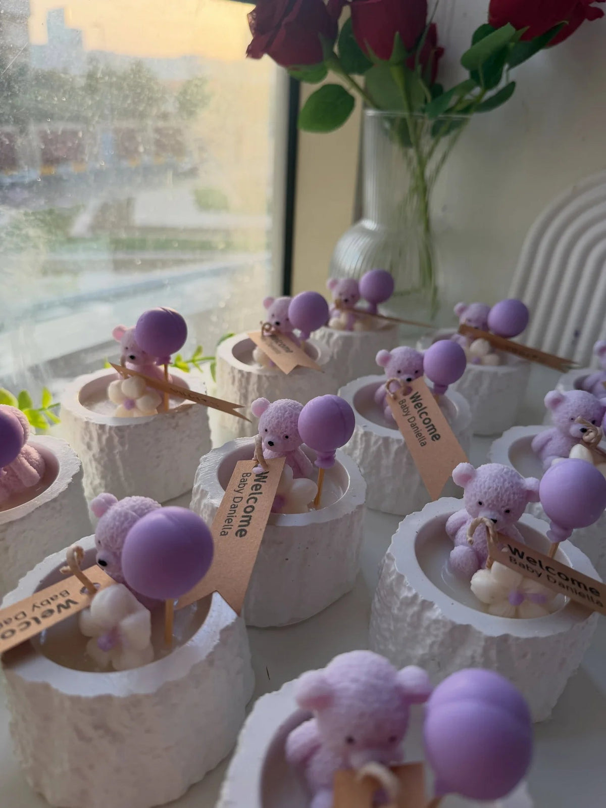Lilac teddy and balloon newborn candle favor in a textured white bowl