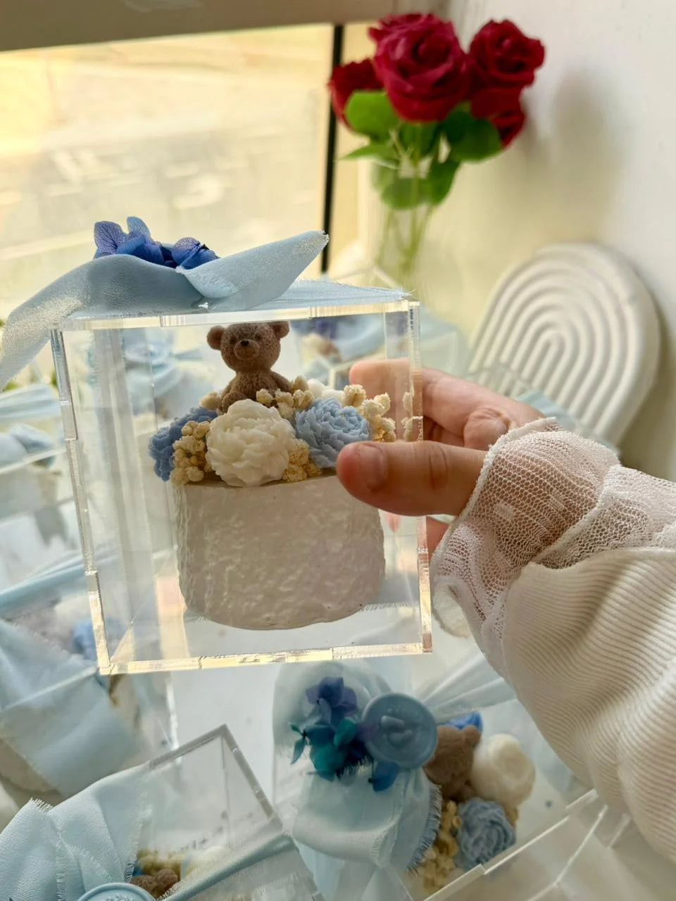 Blue teddy and floral candle favor in acrylic box