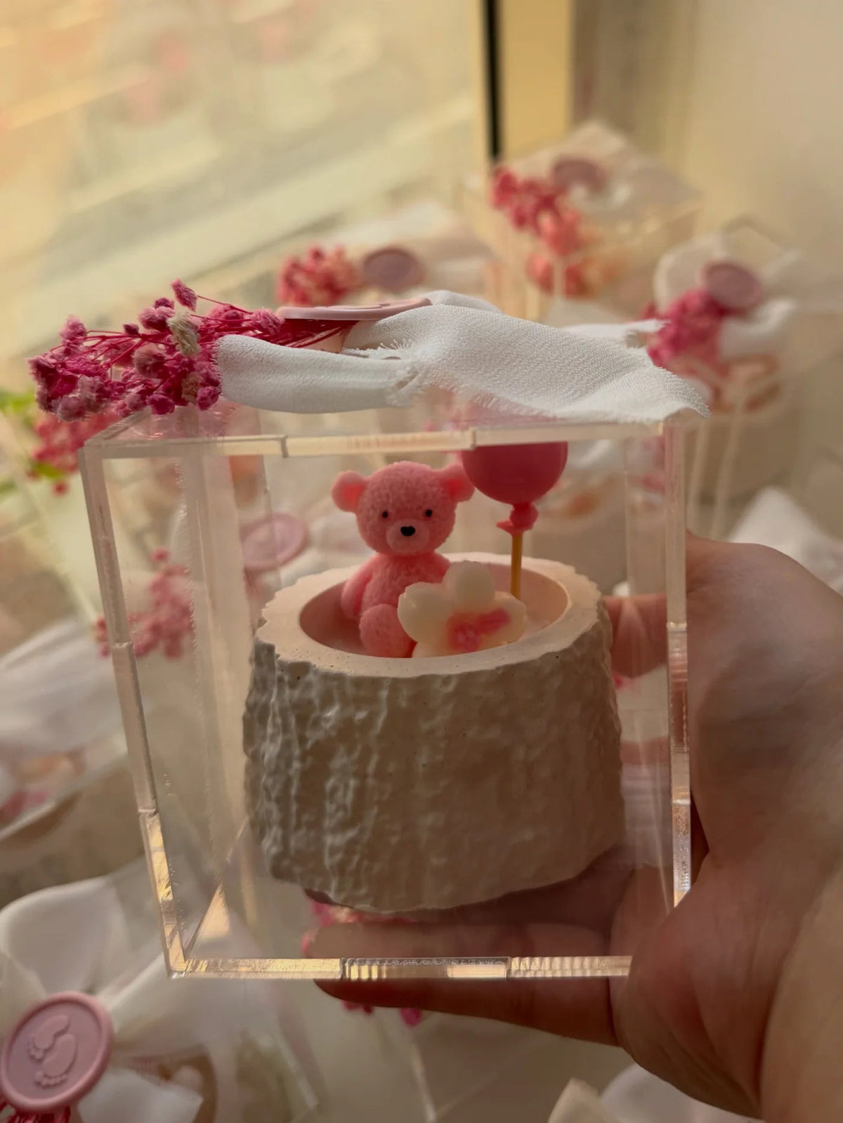 Pink teddy candle favor in a clear acrylic box