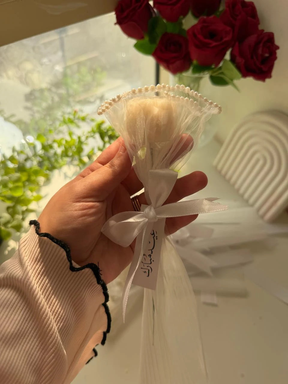 Ivory tulip candle favor in pearl-trimmed tulle with a white satin bow