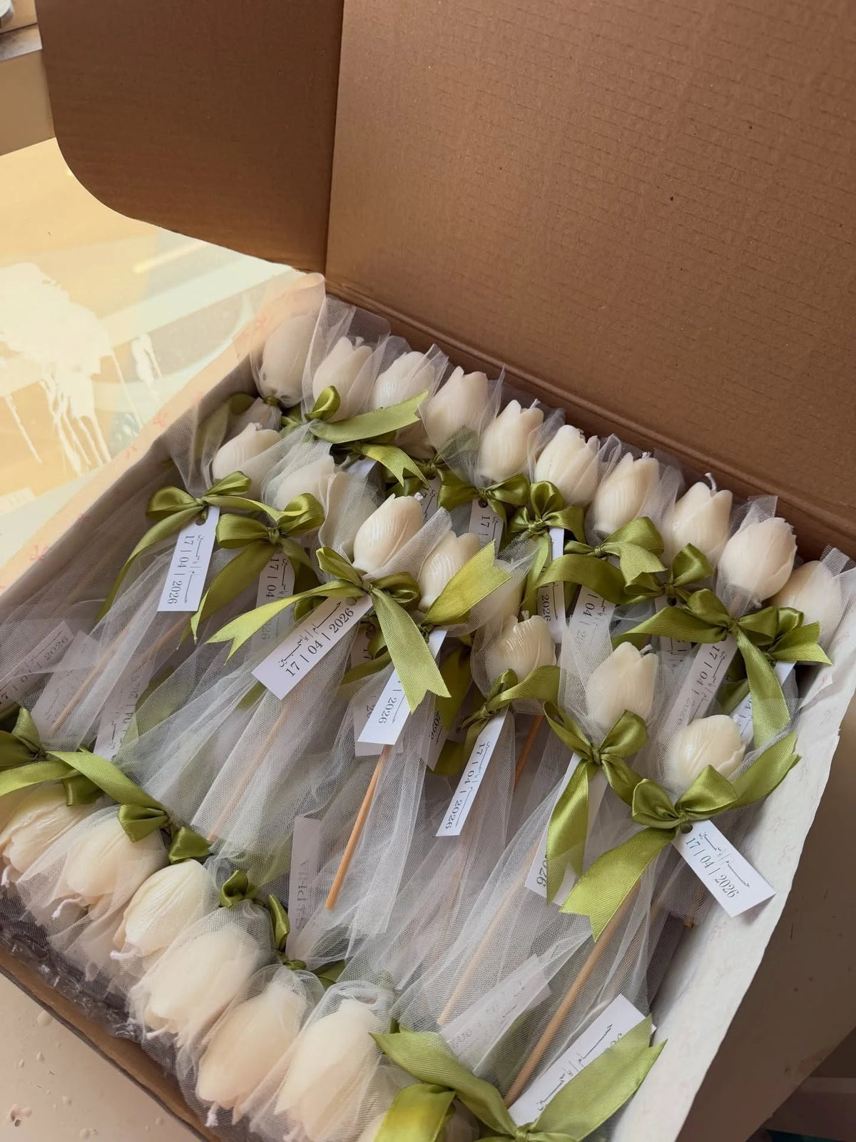 Ivory tulip candle favors with olive green ribbons and customized tags