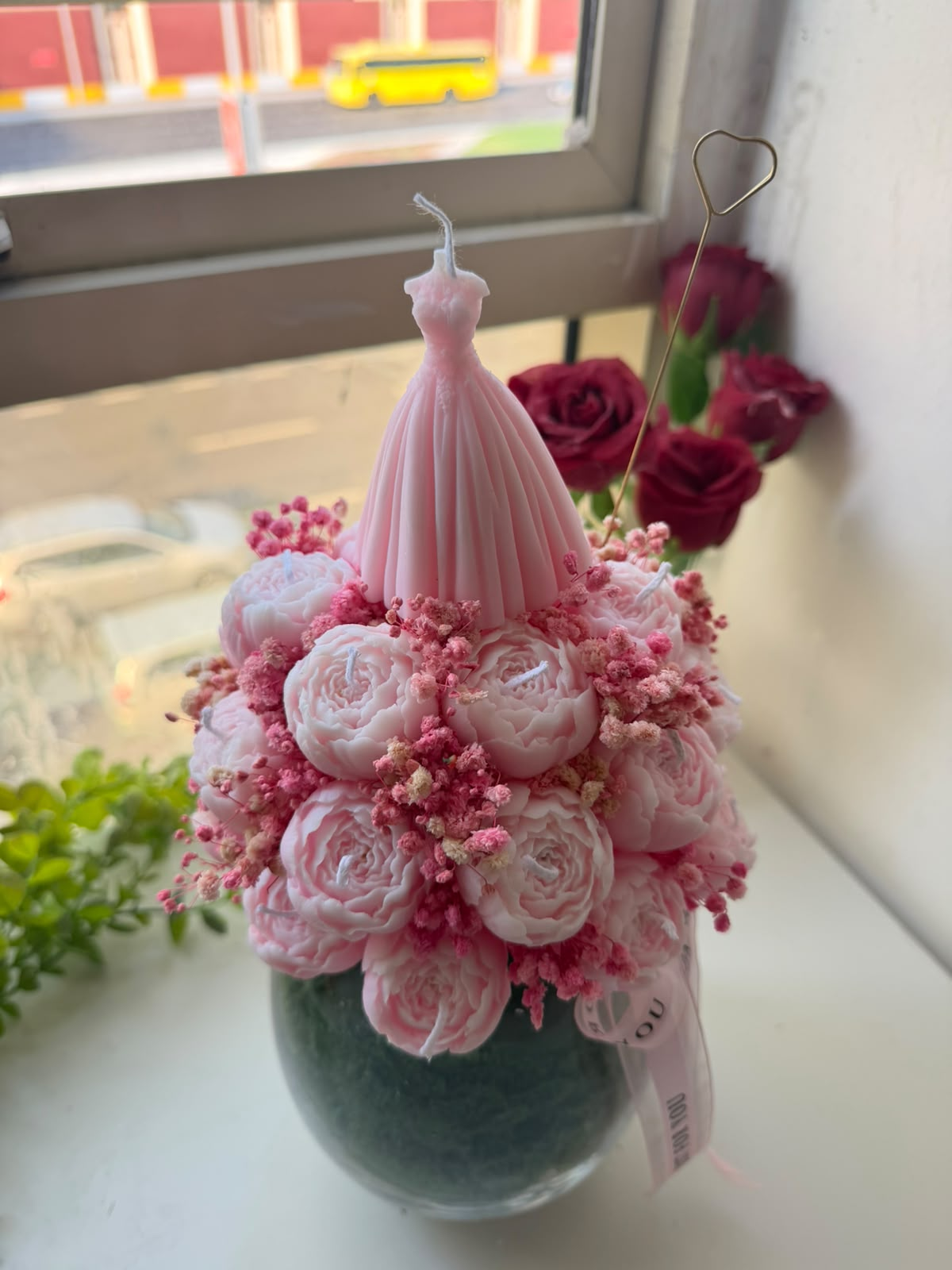 Pink peony candle bouquet with a dress candle in a glass vase