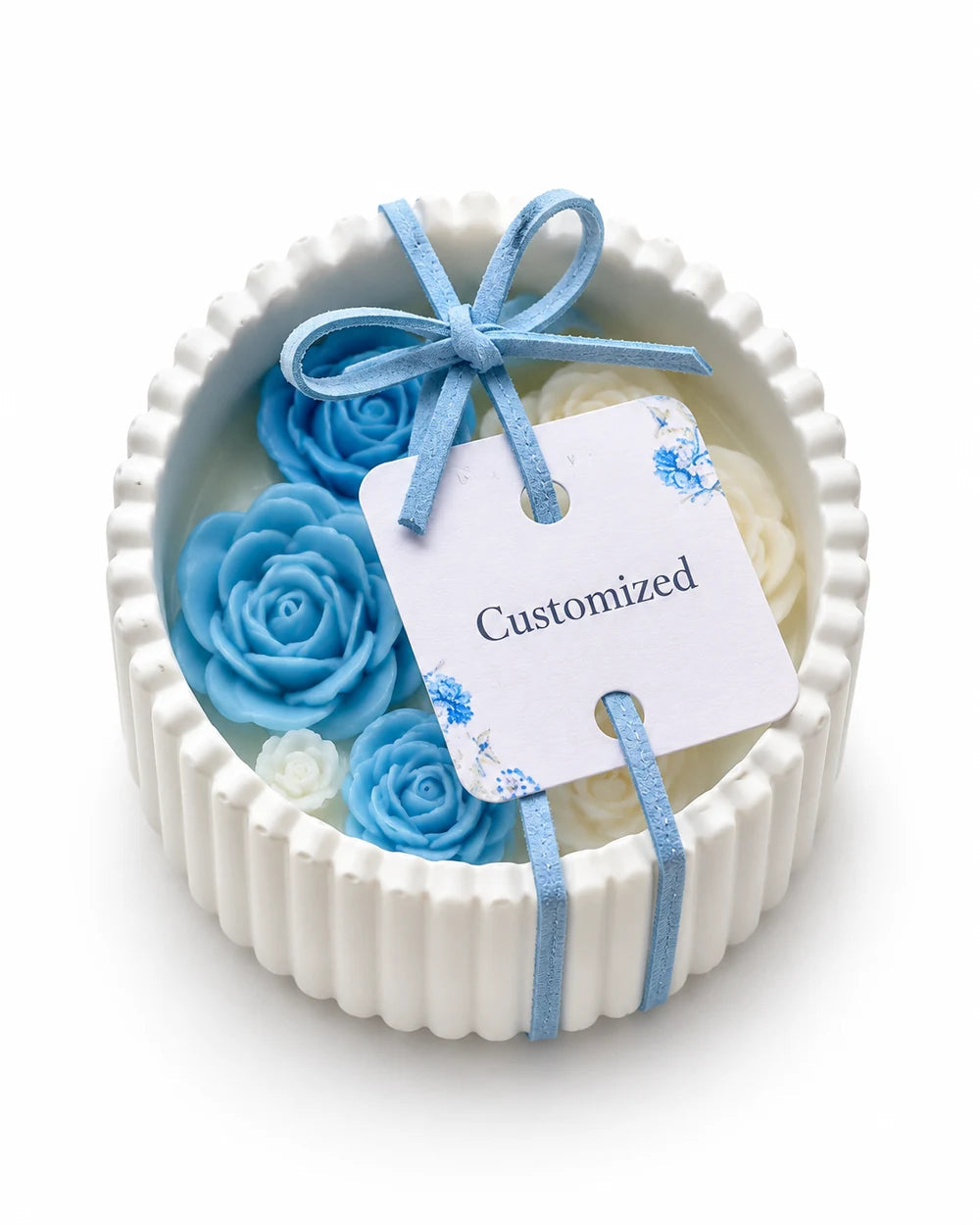 White ribbed bowl candle with blue and ivory wax roses and a personalized tag